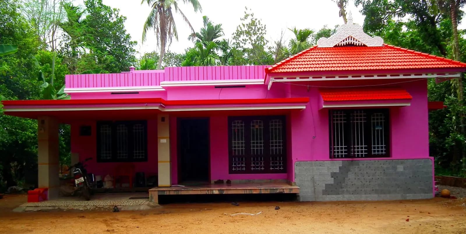 Brightly painted single-storey house with a red tiled roof in Thrissur, Kerala