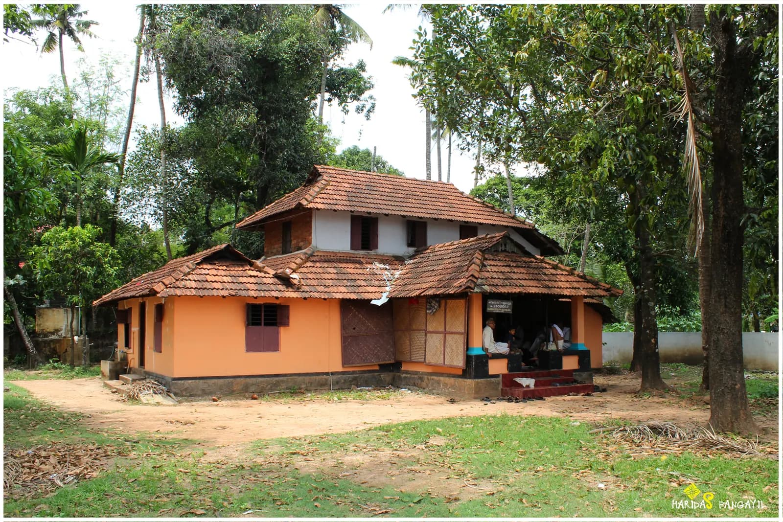 Traditional Kerala house with a tiled roof among trees