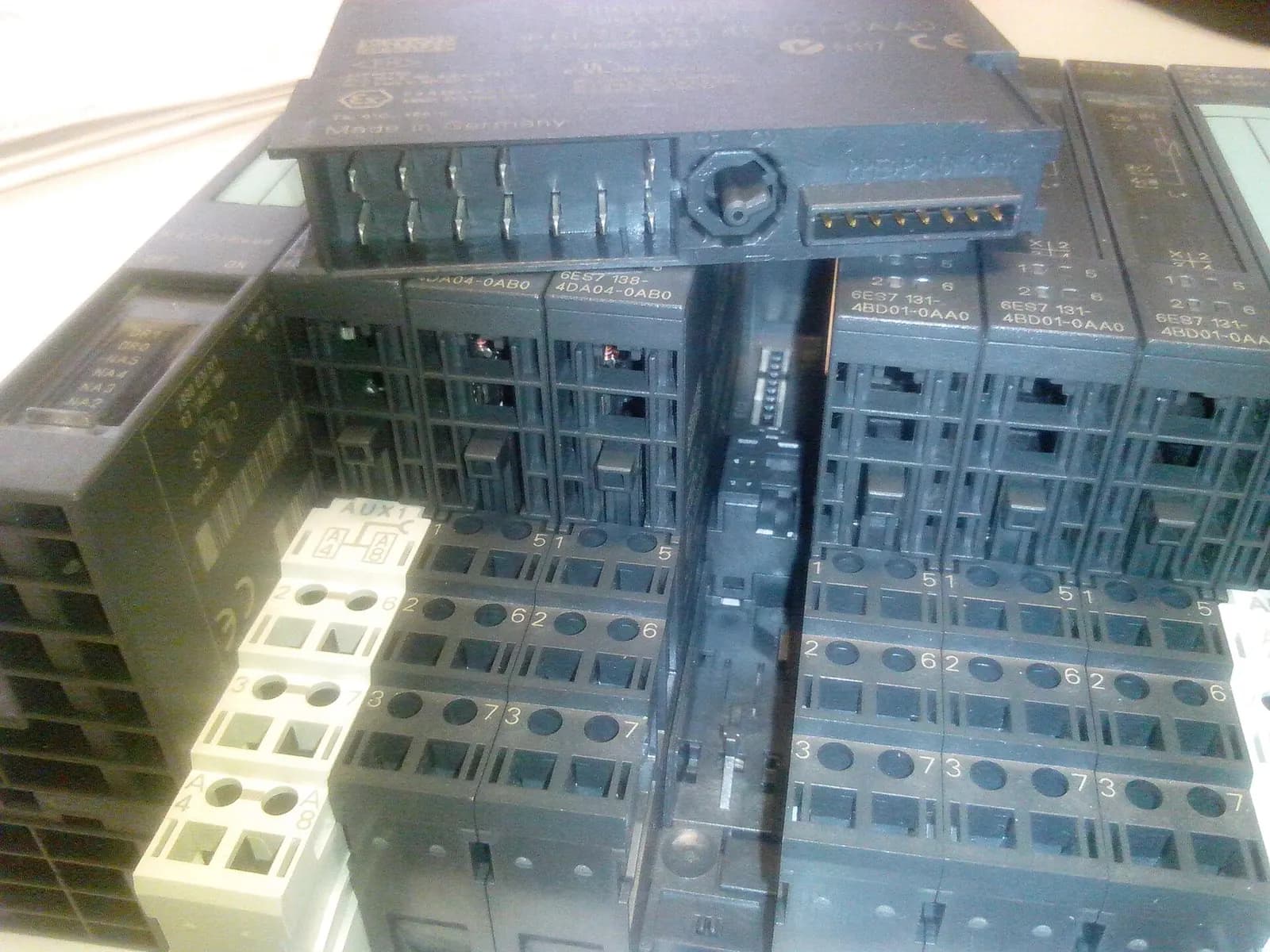 Siemens SIMATIC S7-generation ET 200S I/O modules and terminal blocks stacked on a workbench