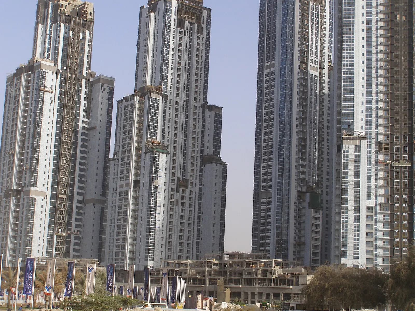 Residential towers under construction in Dubai, with sales banners lining the street in front