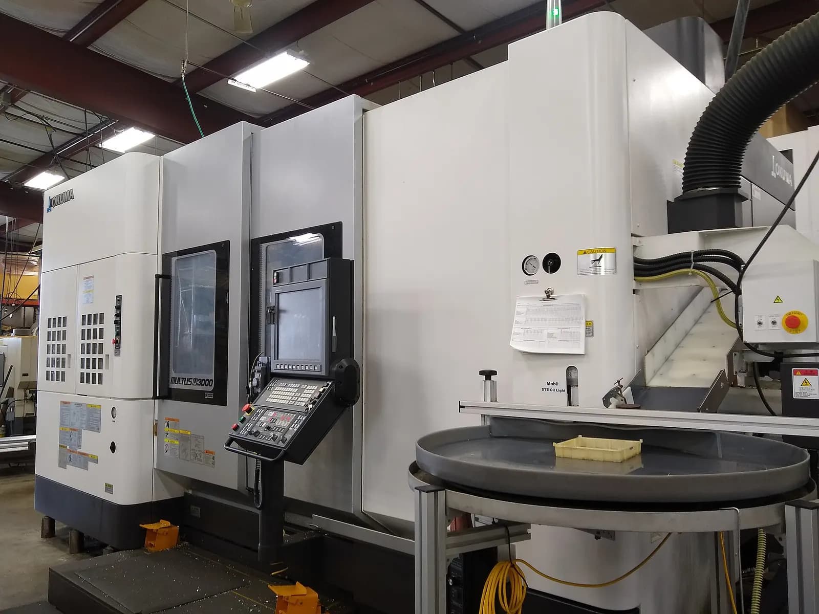 Modern multi-tasking CNC machine tool with enclosed work area and operator control panel in a workshop
