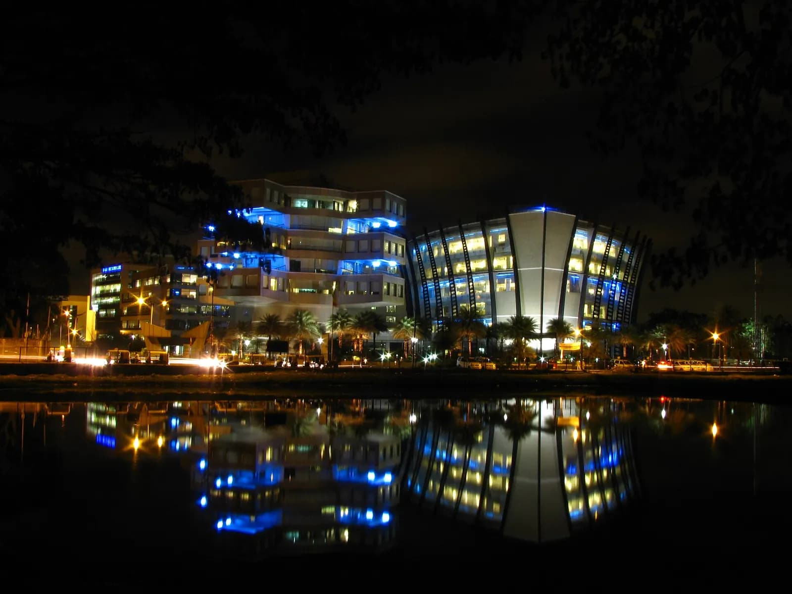 Office buildings of Bagmane Tech Park in Bangalore lit up at night and reflected in a lake