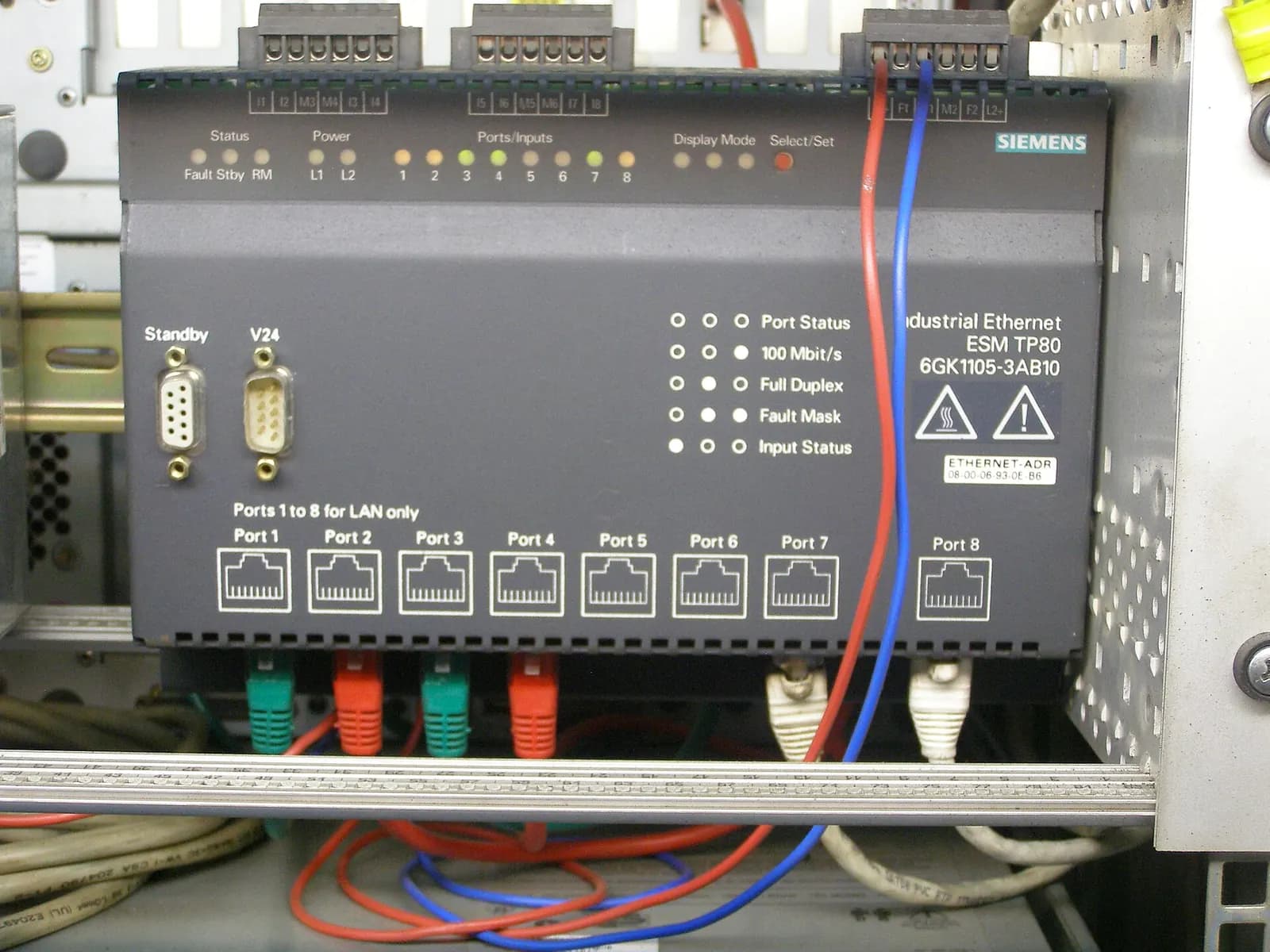 Siemens industrial Ethernet switch with eight RJ45 ports and colour-coded network cables inside a control cabinet