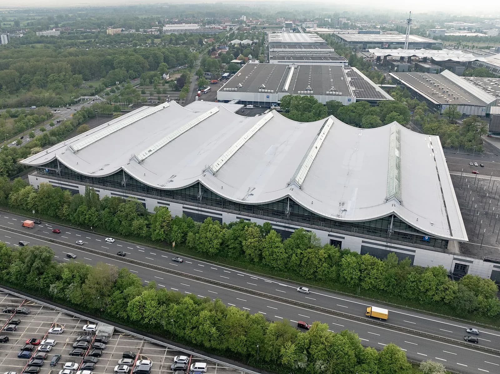 Aerial view of Hall 9 at the Hannover exhibition grounds with its wave-shaped white roof