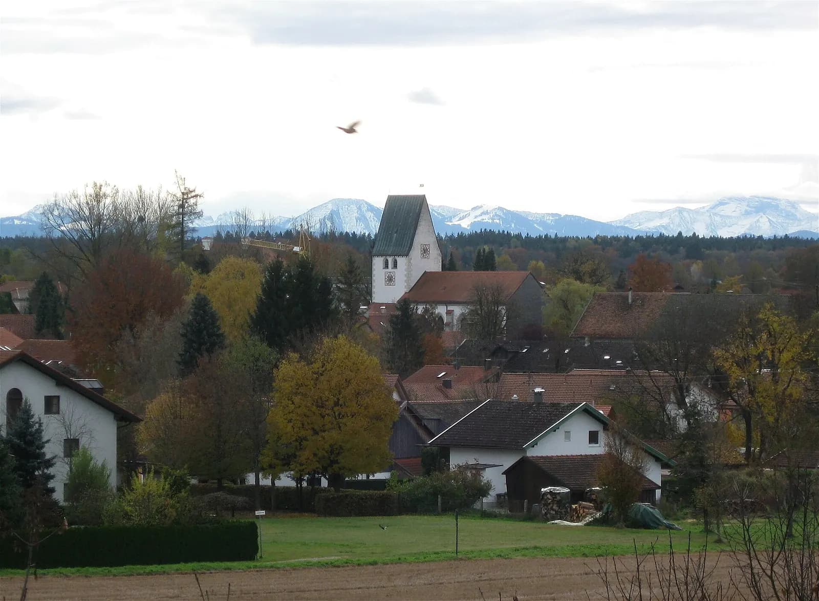 View over the village of Oberhaching south of Munich with its church tower and the Alps on the horizon