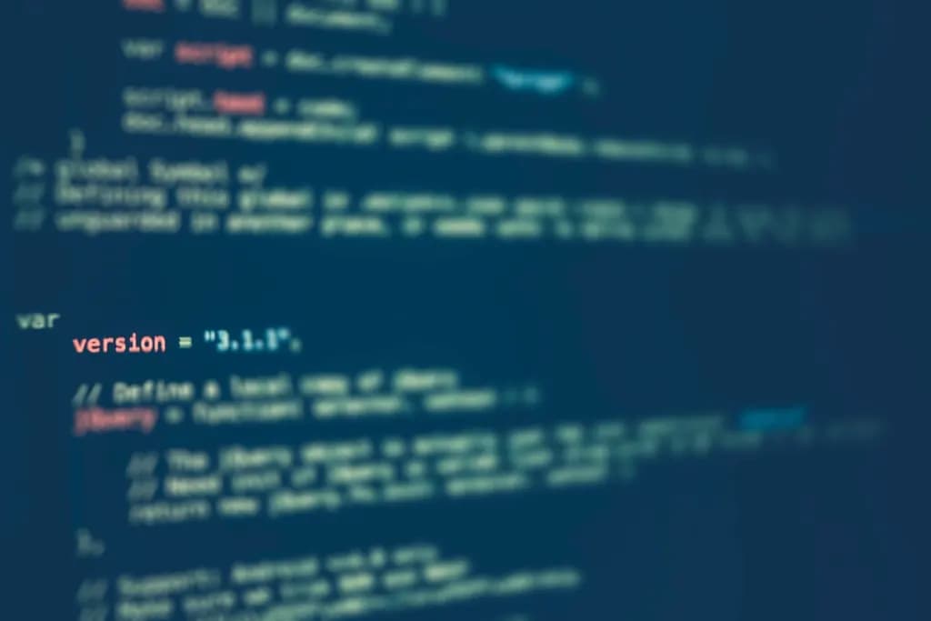 Source code in blue and white text on a dark computer screen, shown out of focus