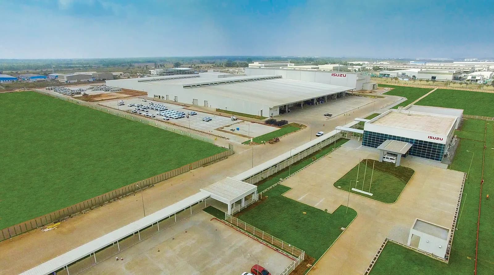 Aerial view of the Isuzu manufacturing plant in India with large factory sheds and green open ground