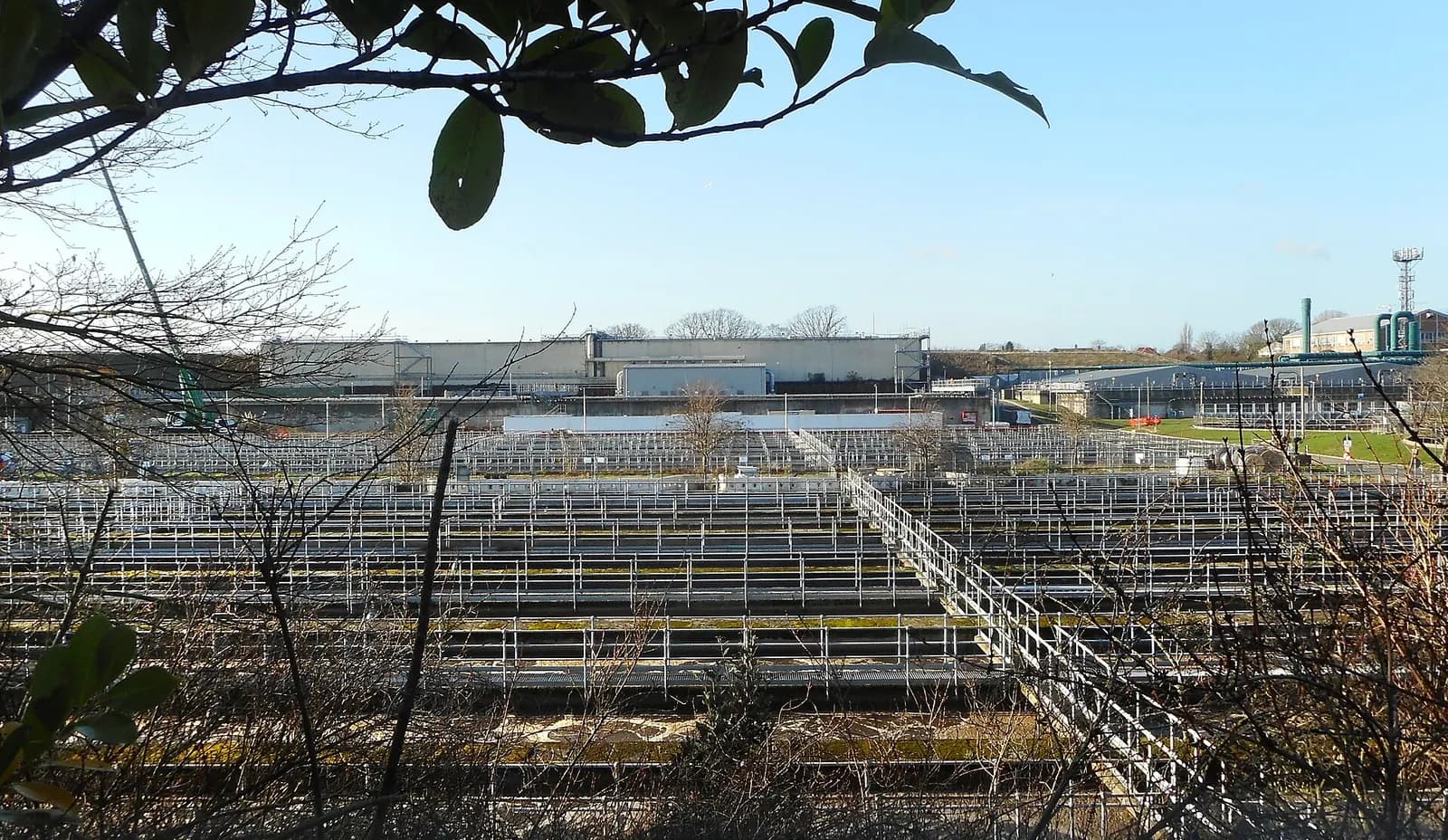 Aerial-style view over the tanks and buildings of Mogden sewage treatment works in west London