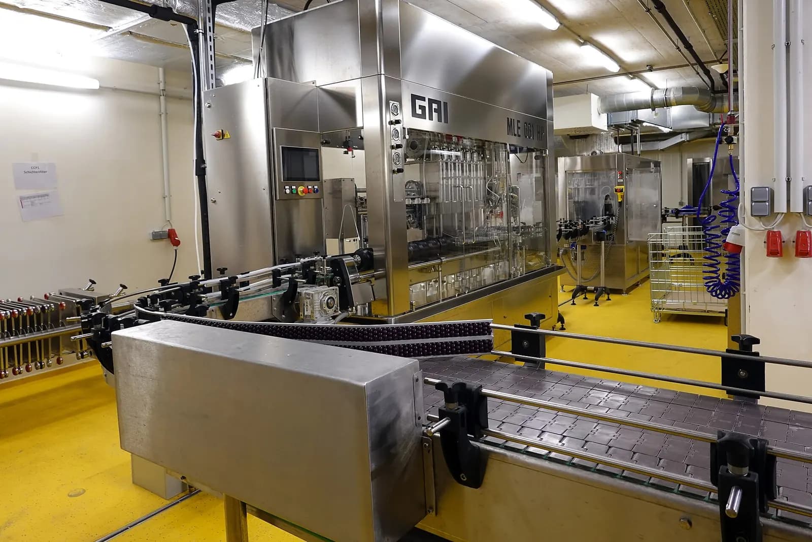 Stainless steel bottle filling and capping line in a bright production hall