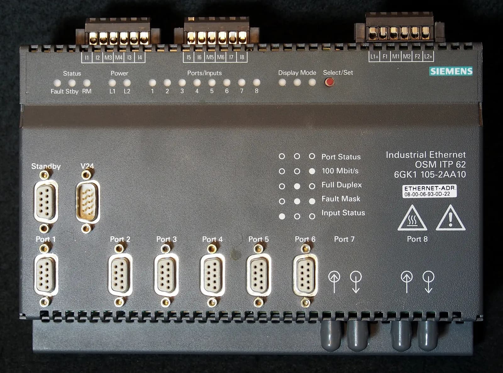 Siemens industrial Ethernet switch with fibre and serial ports on a dark background