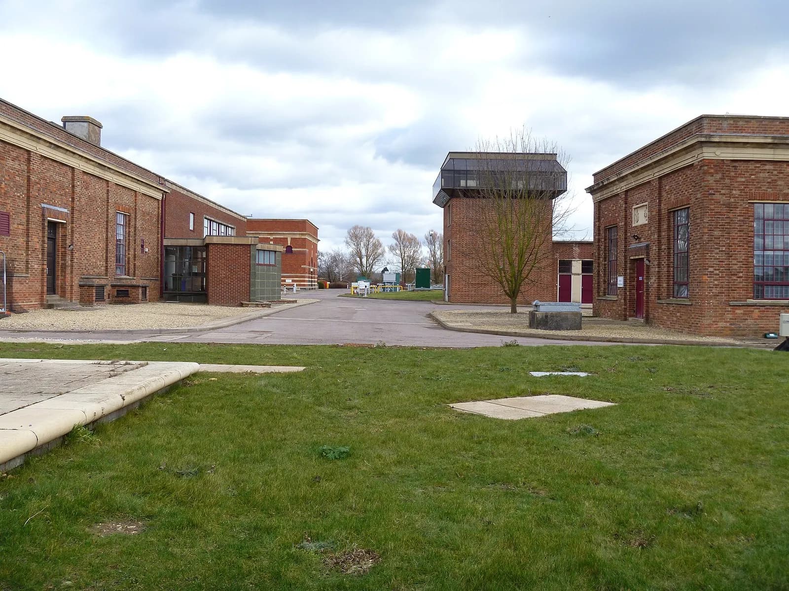 Victorian brick buildings and lawns inside Mythe Water Treatment Works, Gloucestershire