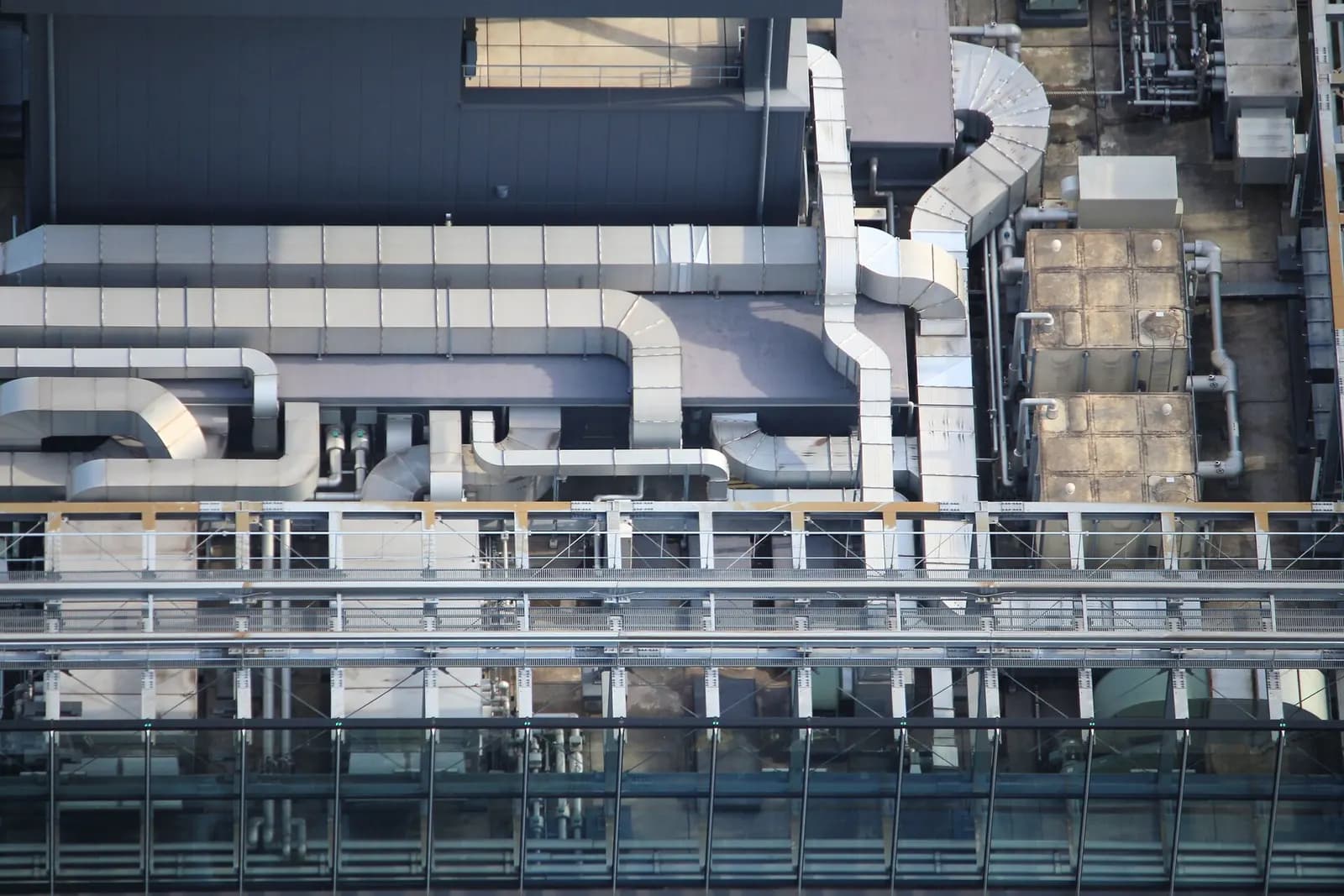 Rooftop of an office building with HVAC plant, air handling units and silver ventilation ductwork.