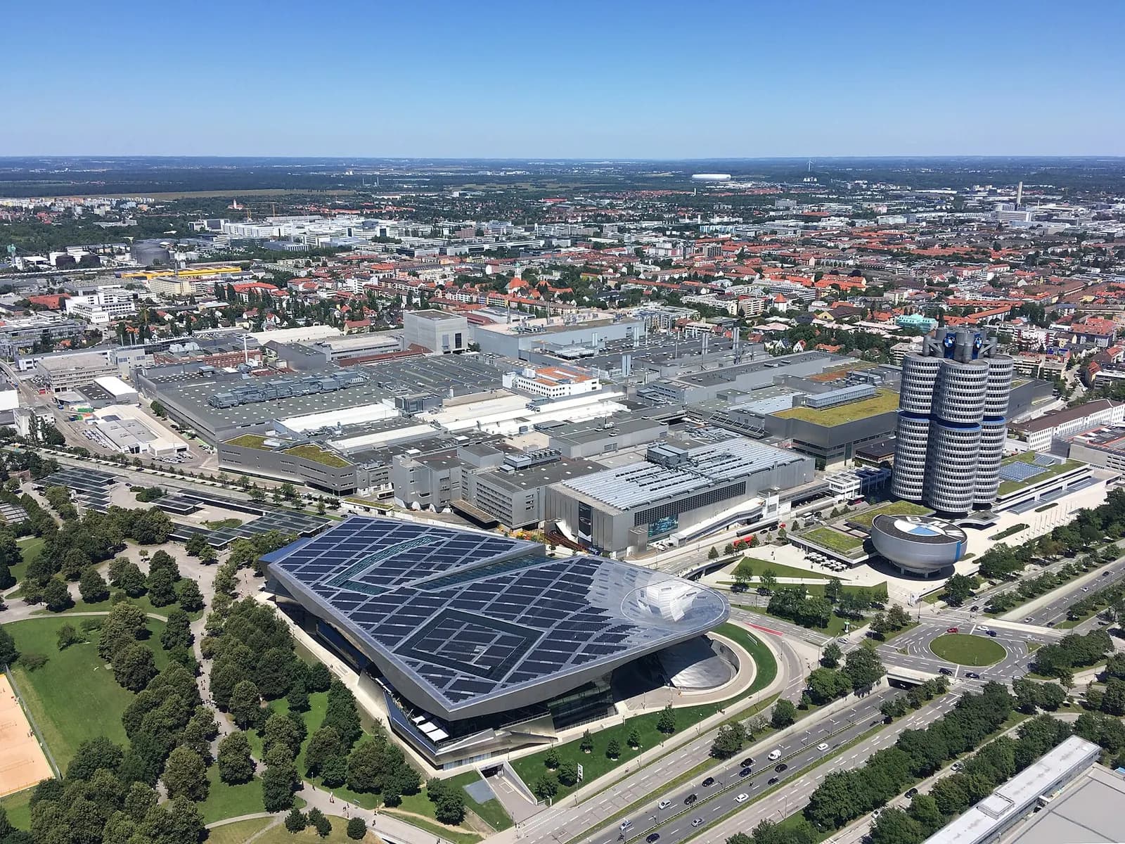 Aerial view of the BMW Munich plant with the four-cylinder headquarters tower and the BMW Welt building.