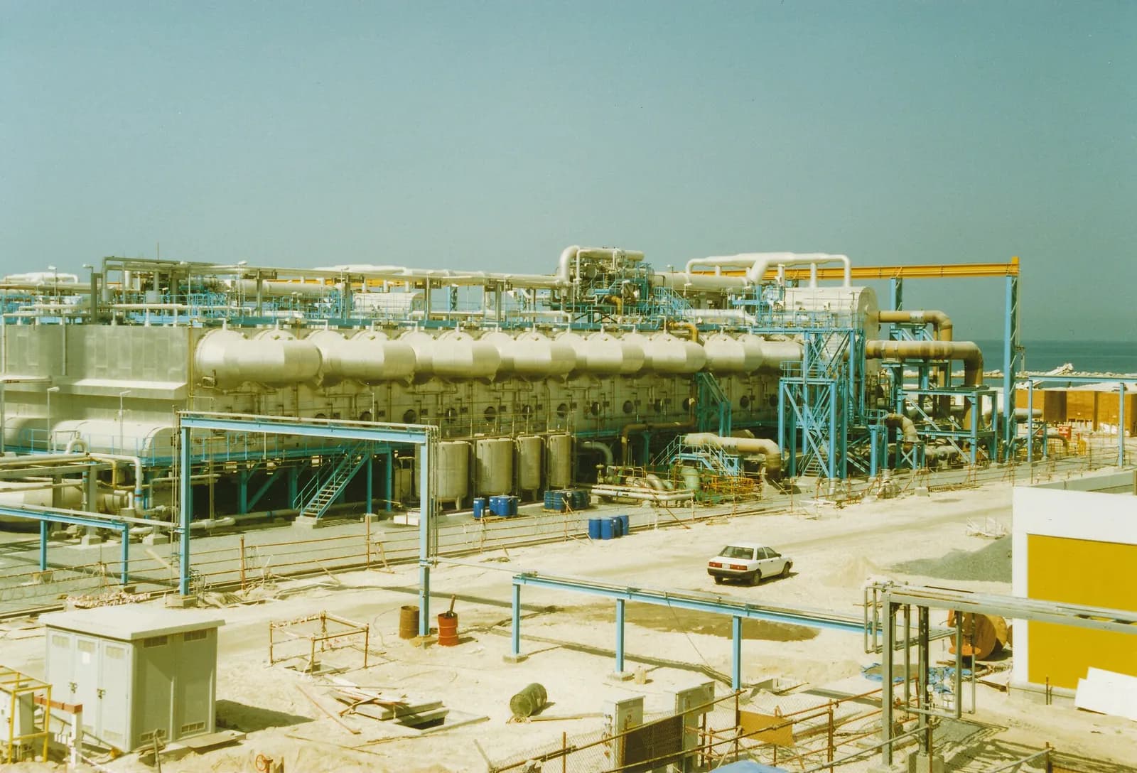 Multi-stage flash desalination plant with large evaporator vessels and pipework at Jebel Ali G Station in Dubai.
