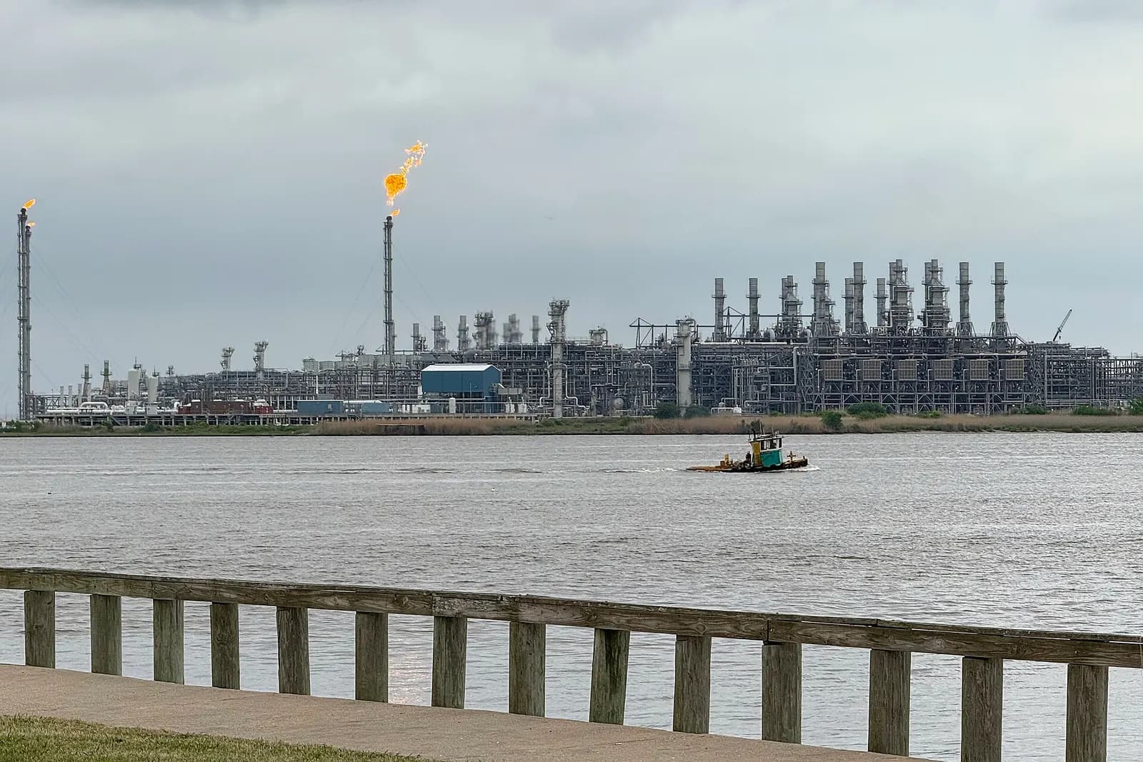 The Sabine Pass LNG terminal with liquefaction trains and a flare stack seen across the water.