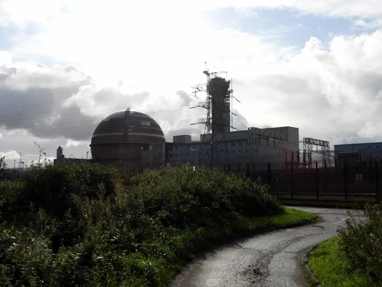 The Sellafield nuclear site in Cumbria with the spherical Windscale reactor building and industrial buildings behind a fence.