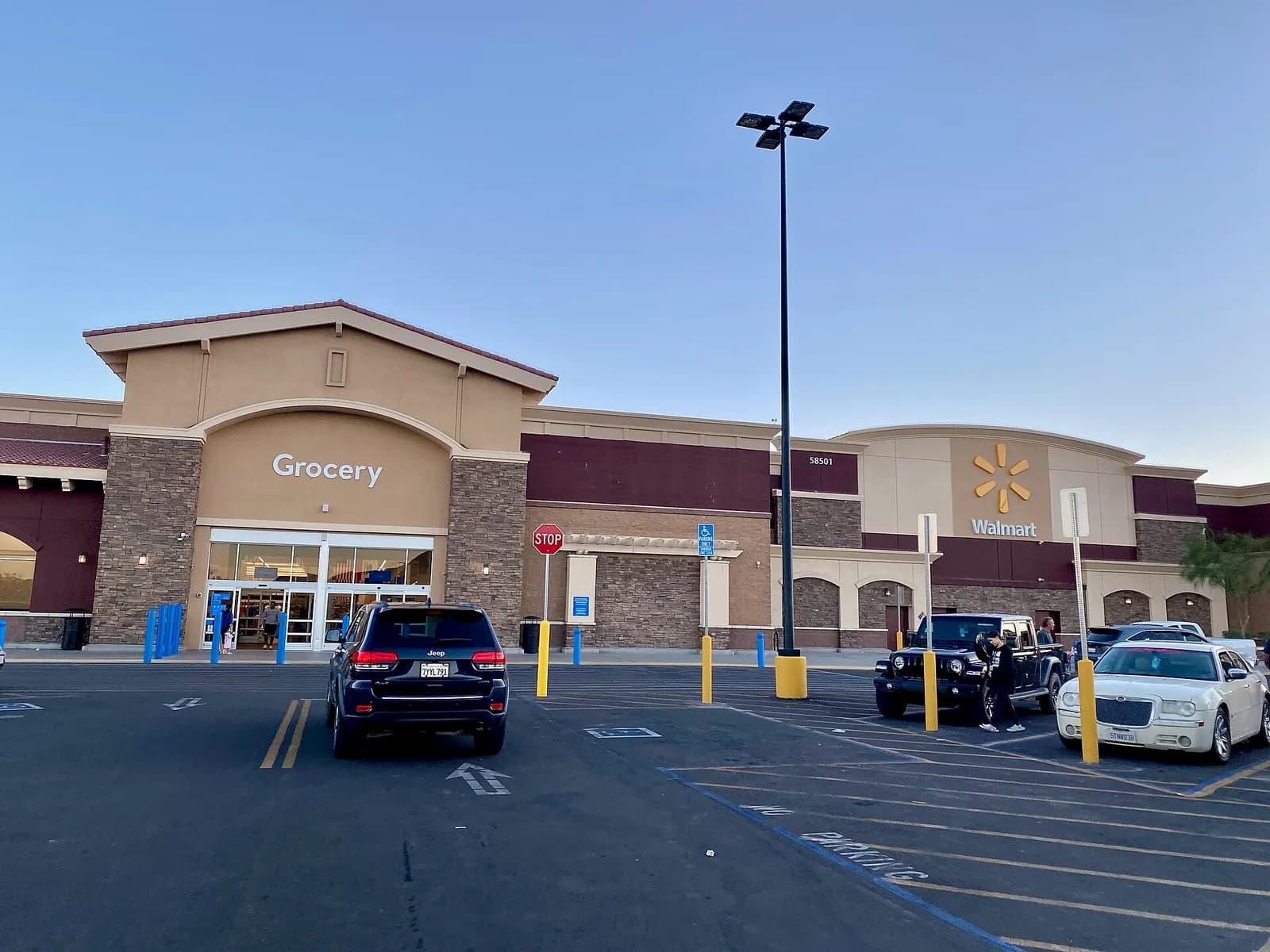 Exterior of a Walmart Supercenter with the grocery entrance and a car park in Yucca Valley, California.